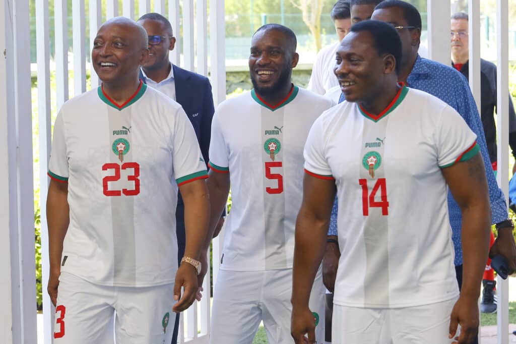 Jay-Jay Okocha laughs in the company of CAF President